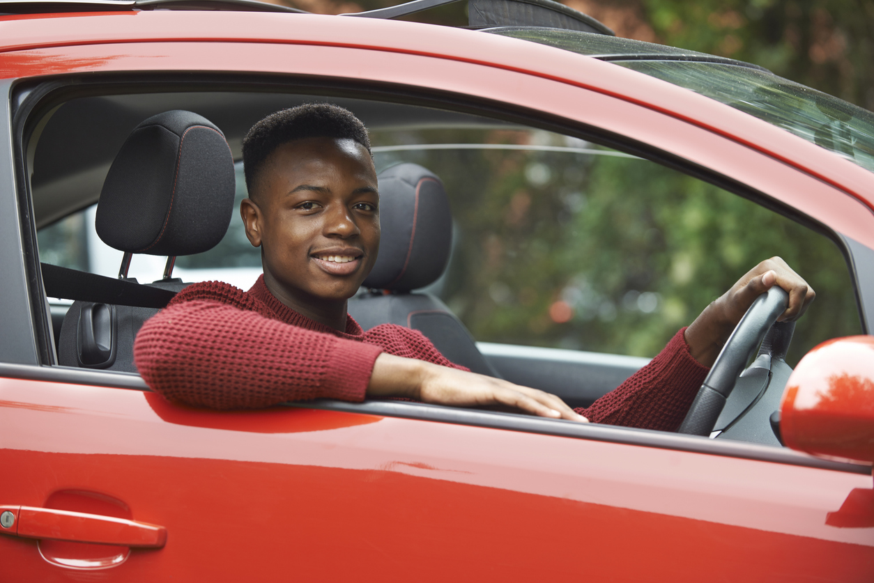Professional chauffeur holding a car door open for a passenger