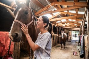 Woman beside a horse at a stable